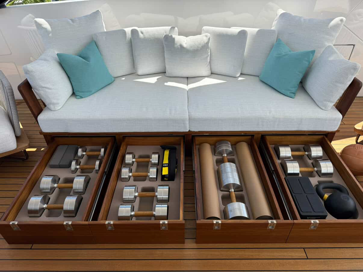 The actual couch — full dumbbell set, TRX bands, and a kettlebell inside, cushions on top